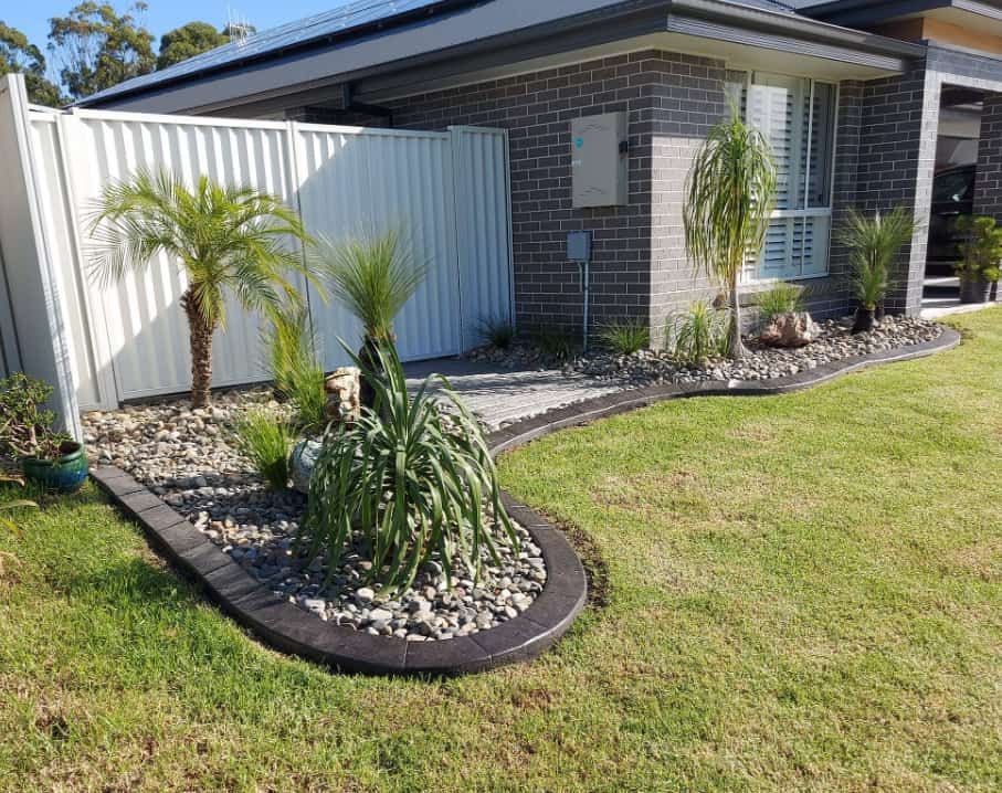 Neatly Landscaped Front Yard Bordered by a Black Edging — Brett's Continuous Garden Edges In Bonny Hills, NSW