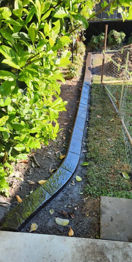 Newly Laid Concrete Garden Edging Curves Through a Backyard — Brett's Continuous Garden Edges In Bonny Hills, NSW
