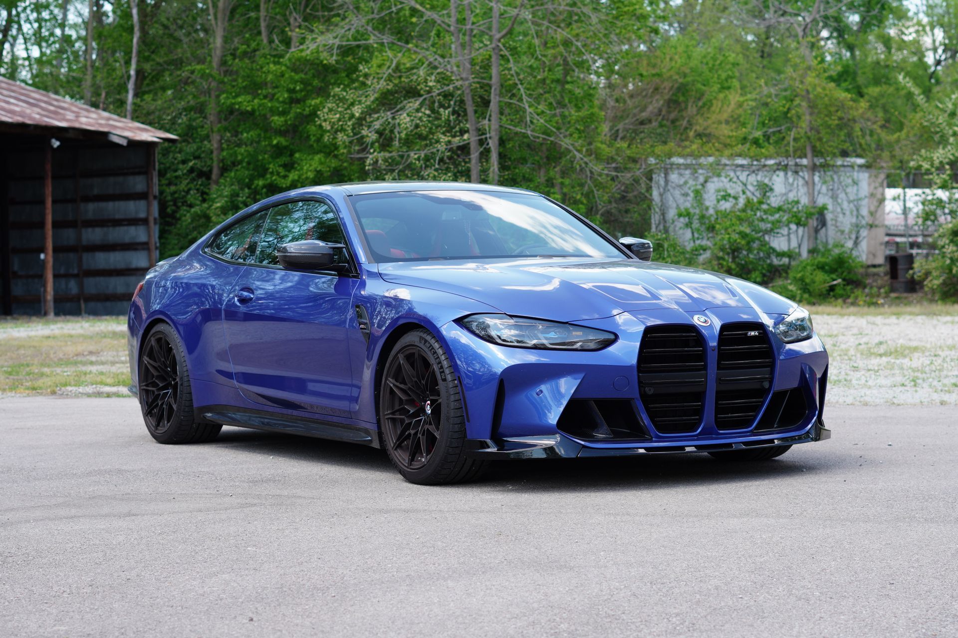 A blue bmw m4 coupe is parked in a parking lot.