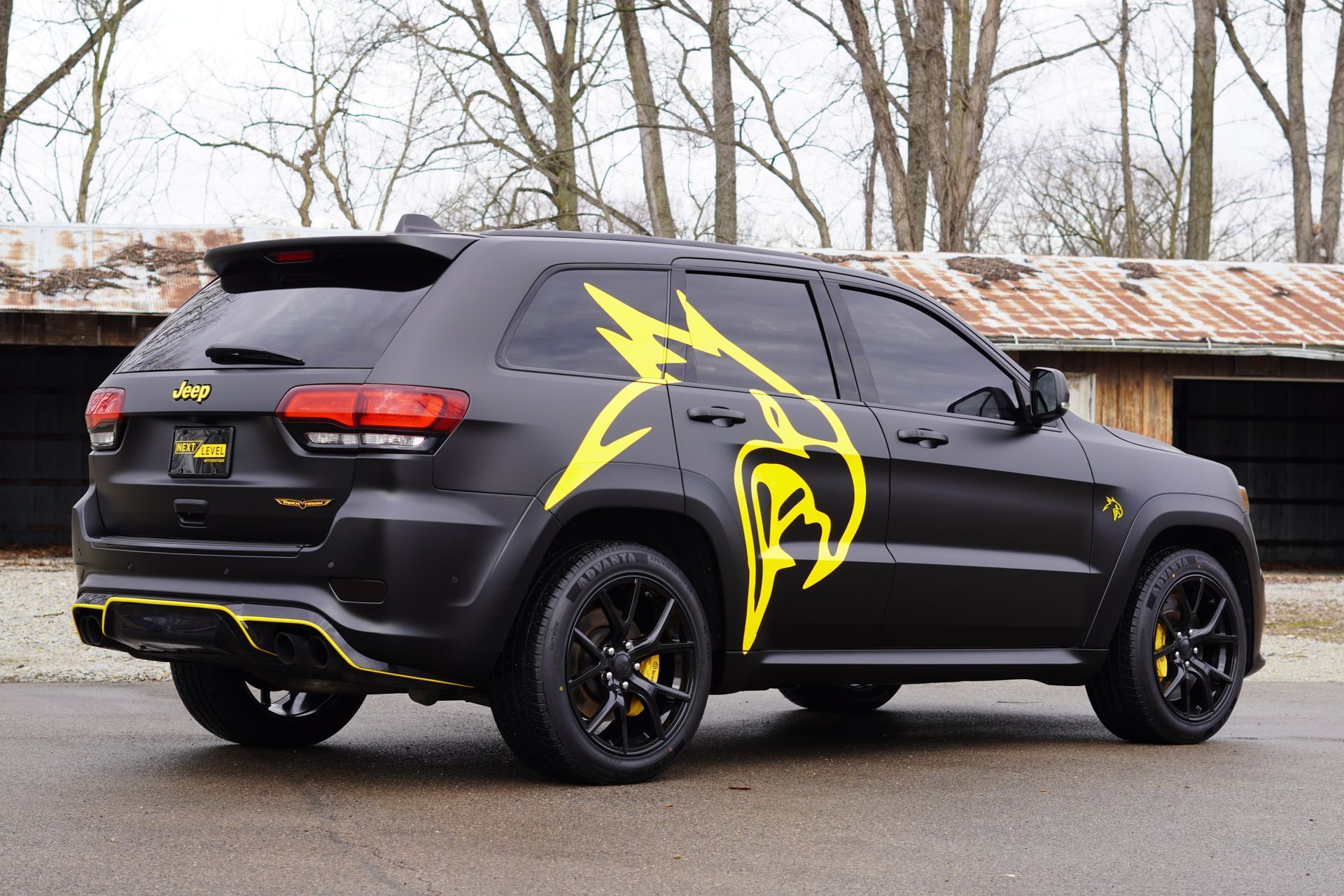 Black SUV with yellow graphics, parked outdoors.