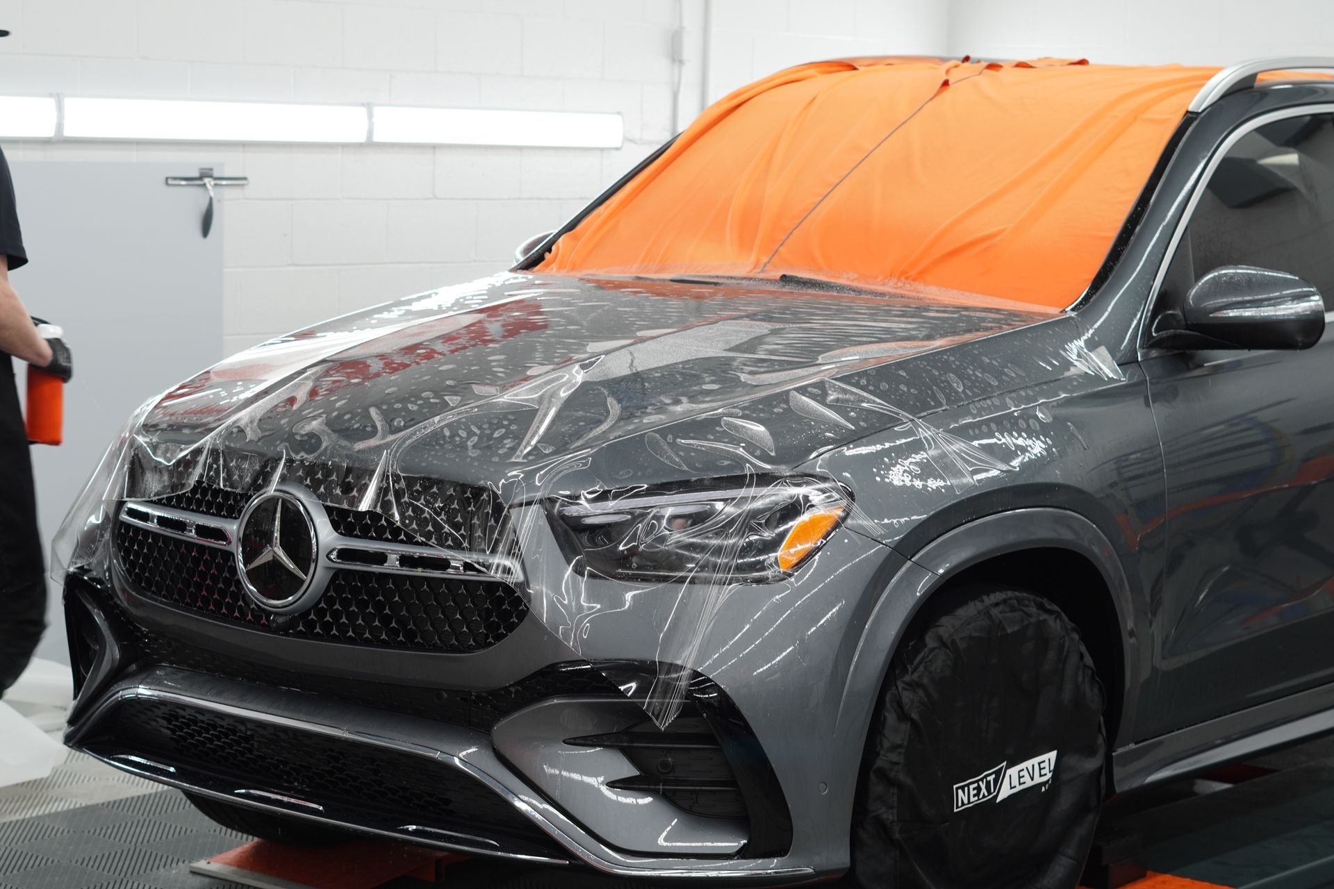 A mercedes benz suv is covered in a protective film.
