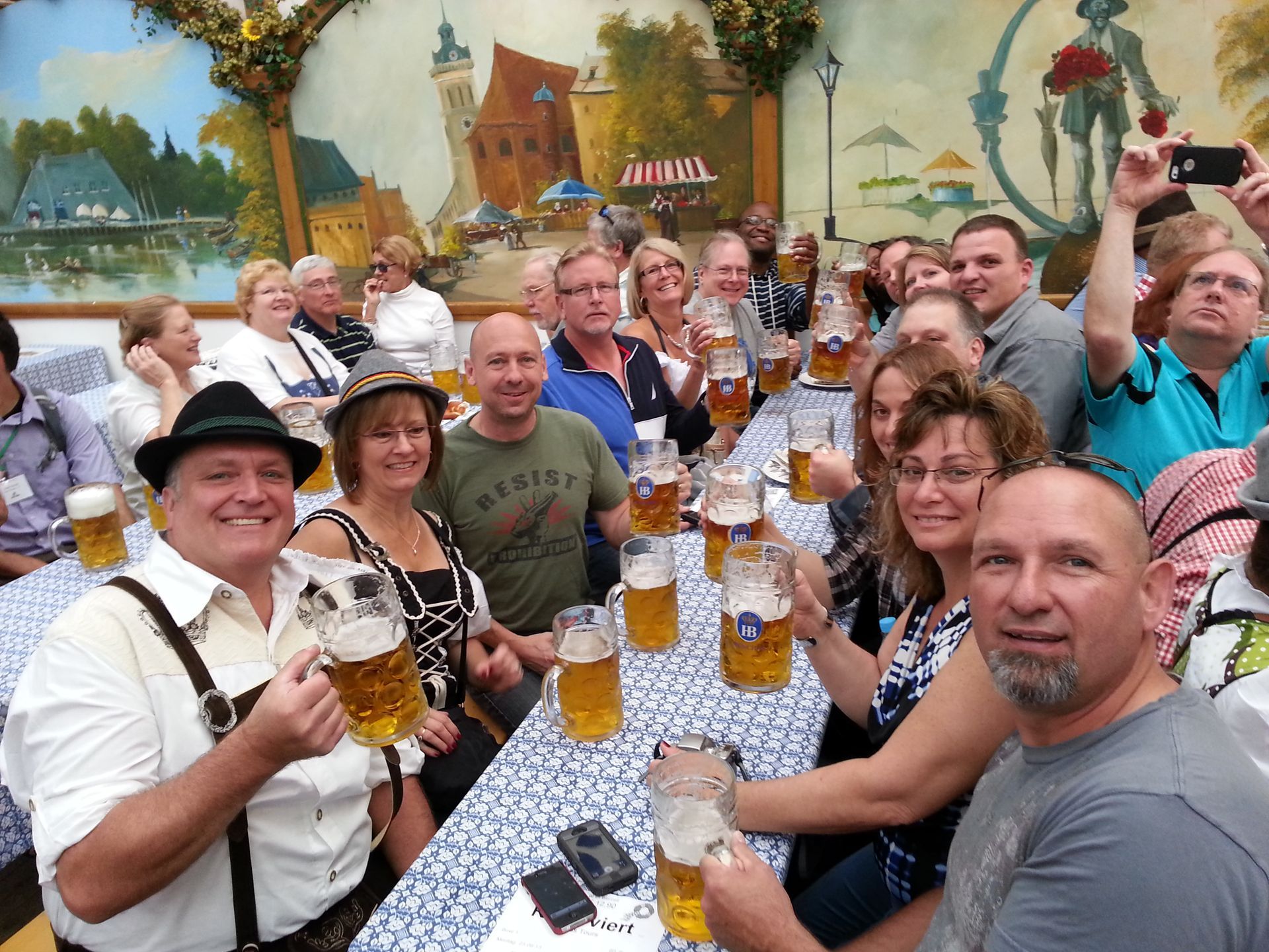 A group of people are sitting at a table holding beer mugs