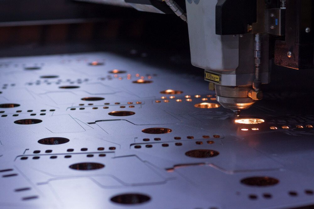 A Machine Is Cutting A Piece Of Metal With Holes In It — Bigdog Welding and Fabrication Pty Ltd In Currajong, QLD