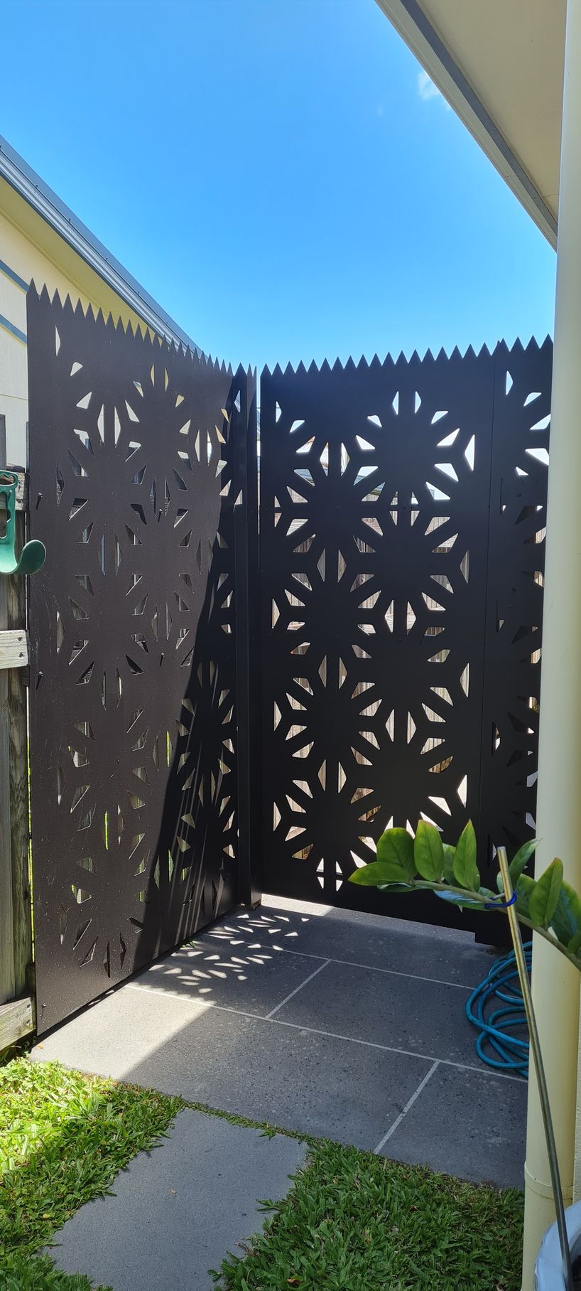 A Fence With A Pattern On It Is In The Backyard Of A House — Bigdog Welding and Fabrication Pty Ltd In Currajong, QLD