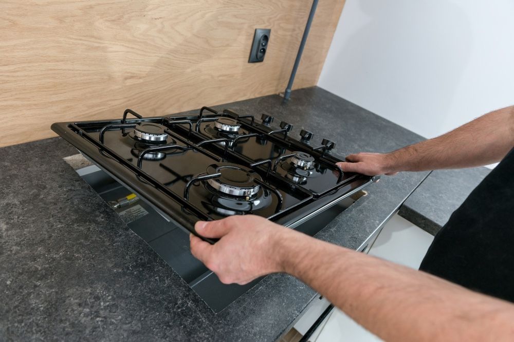 A Black Gas Stove is being Installed — Brightway Electrical in Ballina, NSW