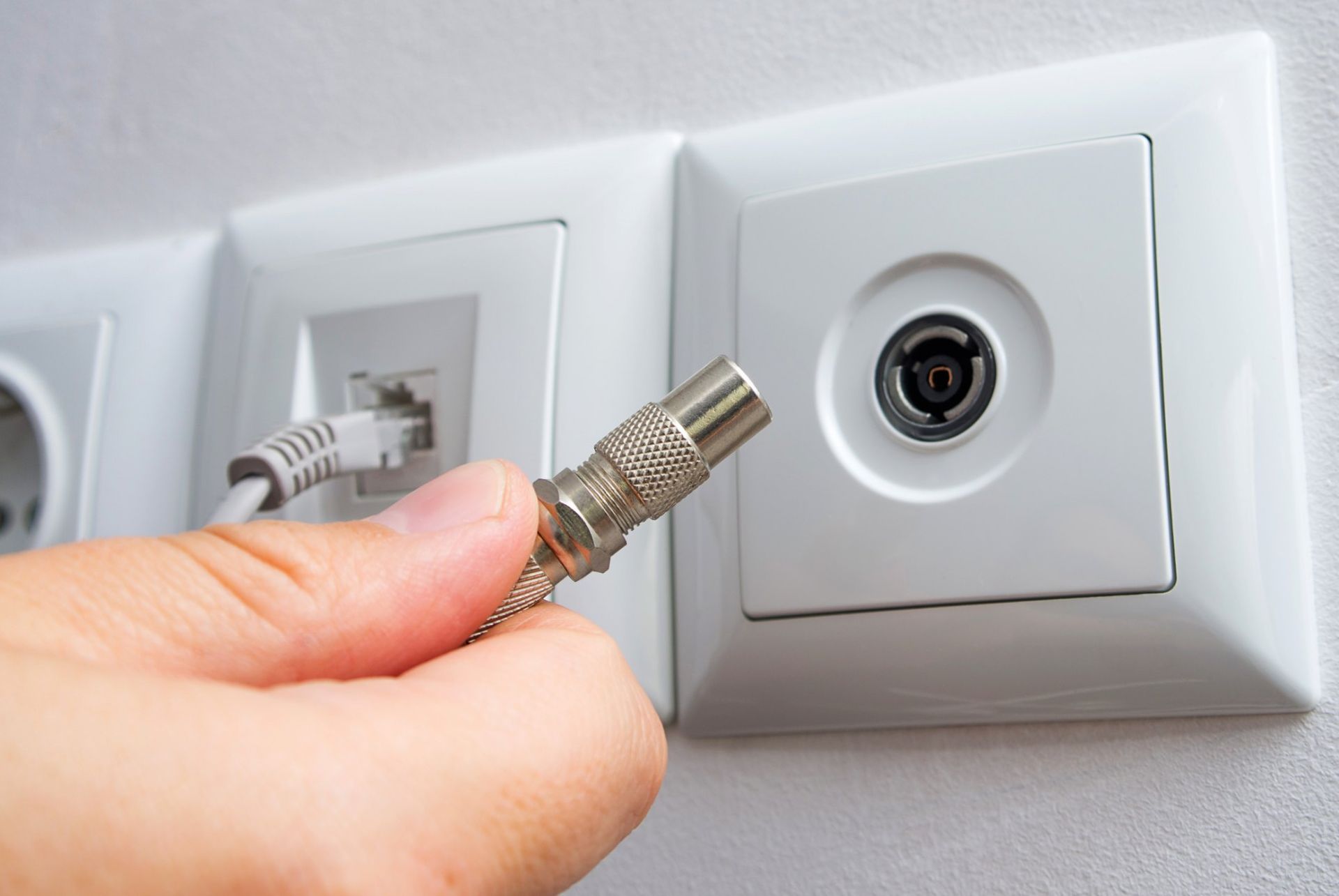 A Person is Plugging a Cable Into an Electrical Outlet — Brightway Electrical in Mullumbimby, NSW