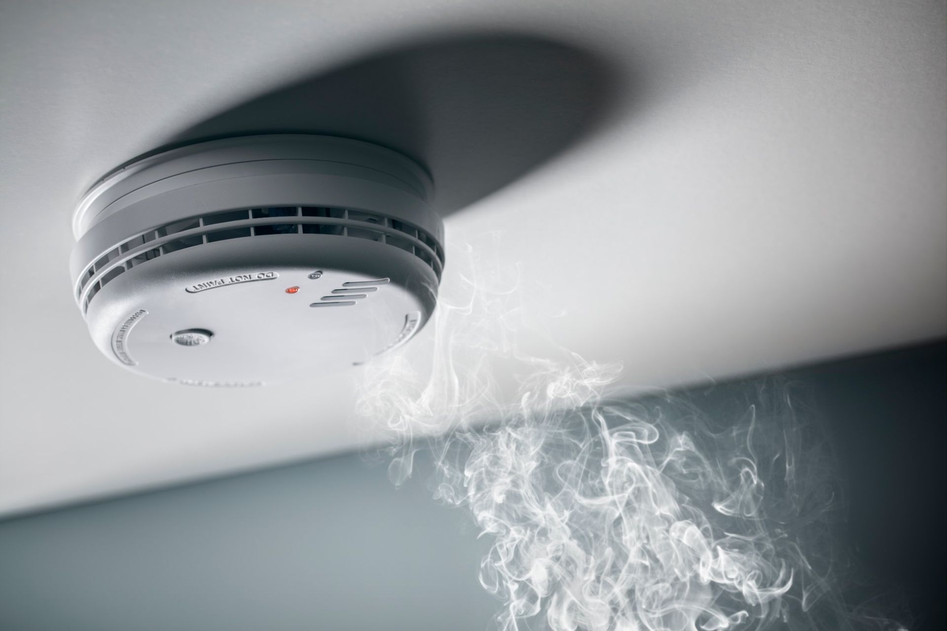 A Smoke Detector on the Ceiling With Smoke Coming Out of It — Brightway Electrical in Ballina, NSW