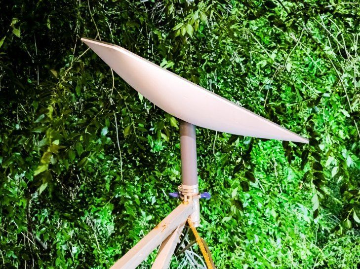 A Satellite Dish is Sitting in Front of a Green Wall — Brightway Electrical in Ballina, NSW