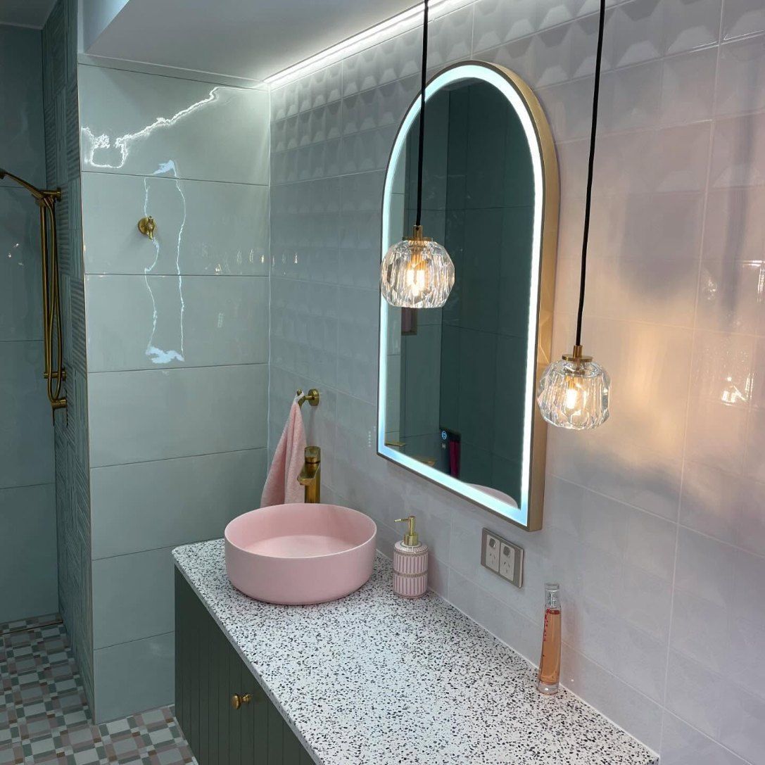 A Bathroom With a Pink Sink and a Mirror — Brightway Electrical in Lennox Head, NSW