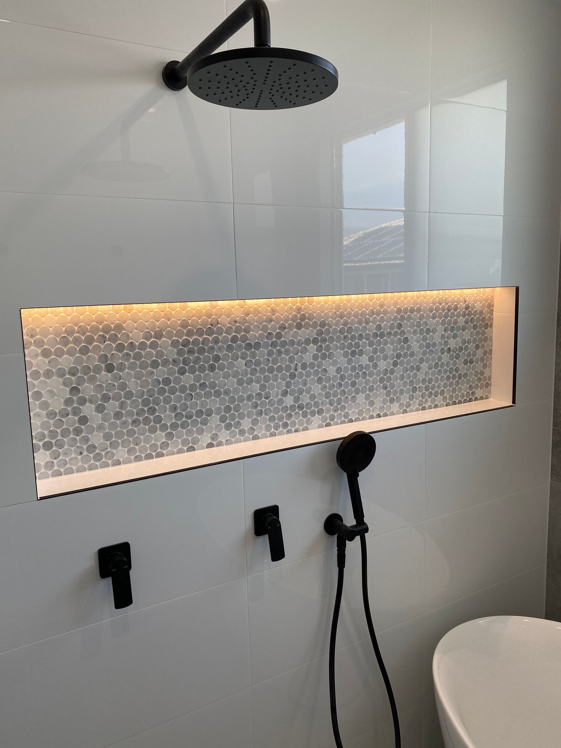 A tiled shower with LED light and black tapwear — Brightway Electrical in Ballina, NSW