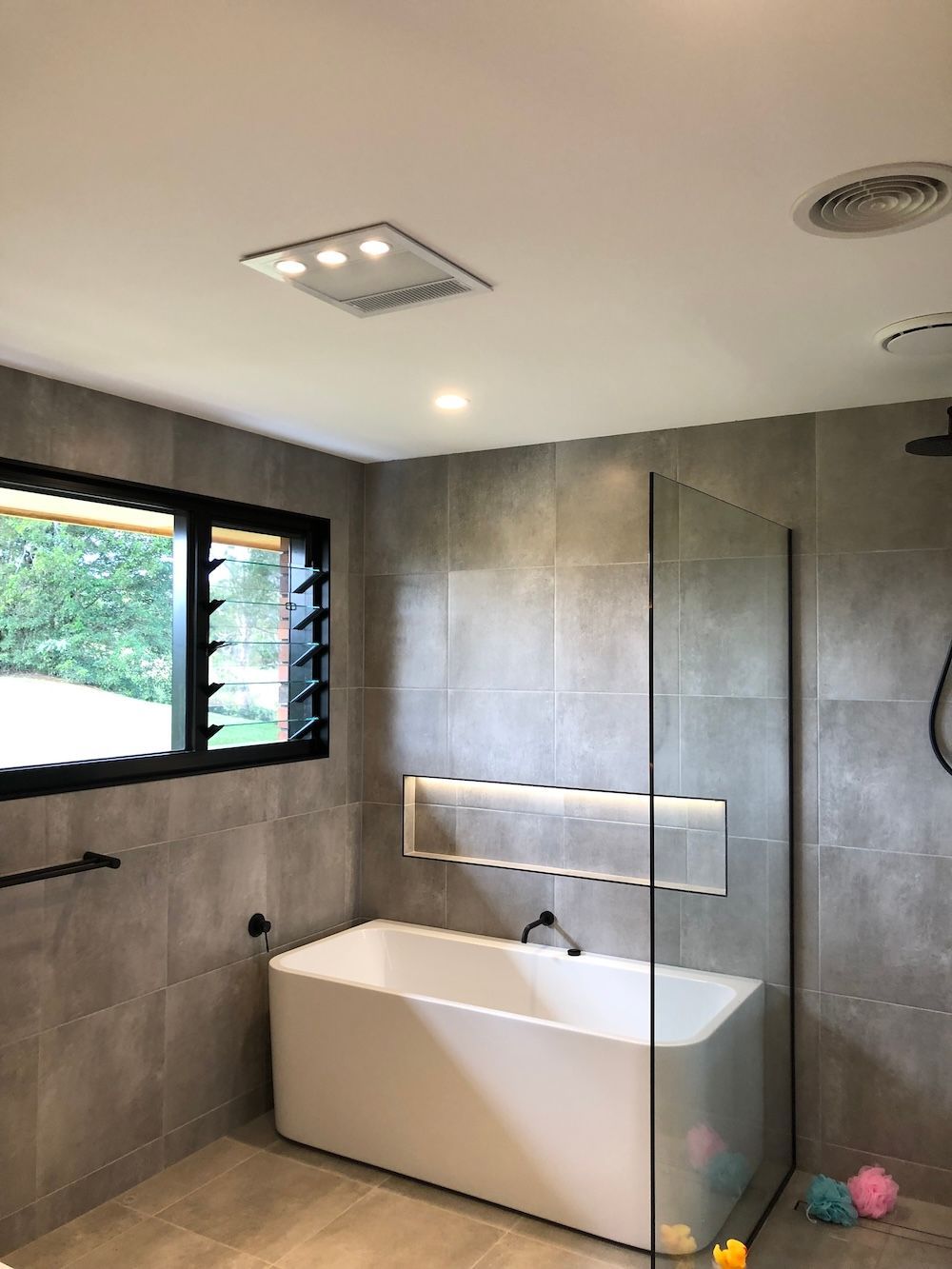 A Bathroom with a Window and Glass Open Shower — Brightway Electrical in Ballina, NSW