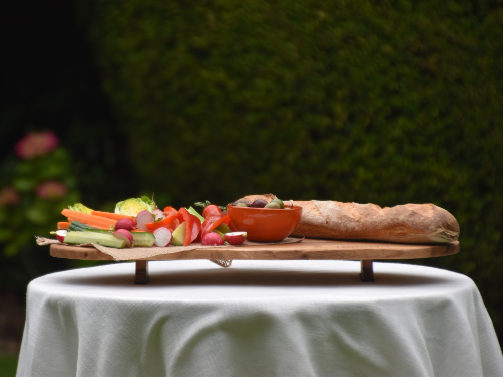 Grazing board with bread and vegetables on an outside table, used for restaurants, catering or home entertaining.