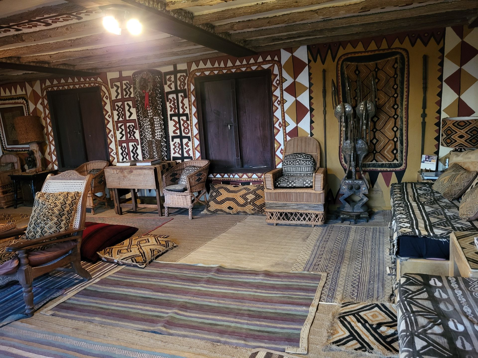 Interior room with patterned textiles, wooden furniture, and decorative elements.