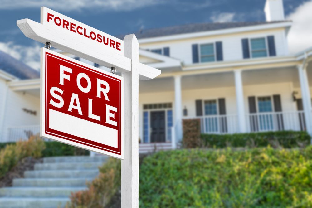 Foreclosure Sign in Front of a White House With a Green Hill and Blue Sky — Diamond Real Estate QLD in Mango Hill, QLD