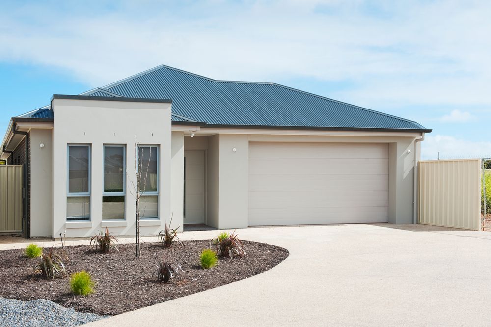 Beige House With Blue Roof, Garage, and Driveway. Landscaping in Front — Diamond Real Estate QLD in Murrumba Downs, QLD