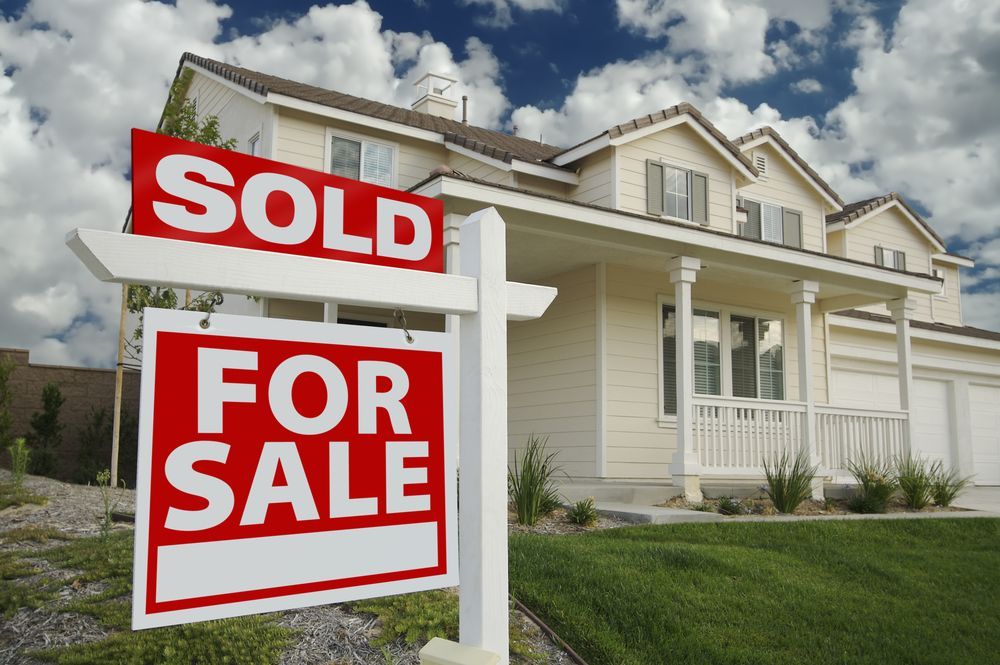 Sold for Sale Sign in Front of a Beige House With Green Lawn — Diamond Real Estate QLD in Murrumba Downs, QLD