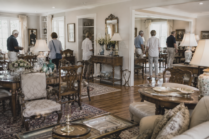 Elegant living room with guests mingling around a dining area and fireplace.