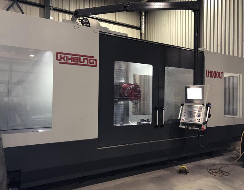 A large, white and dark gray industrial CNC milling machine labeled 