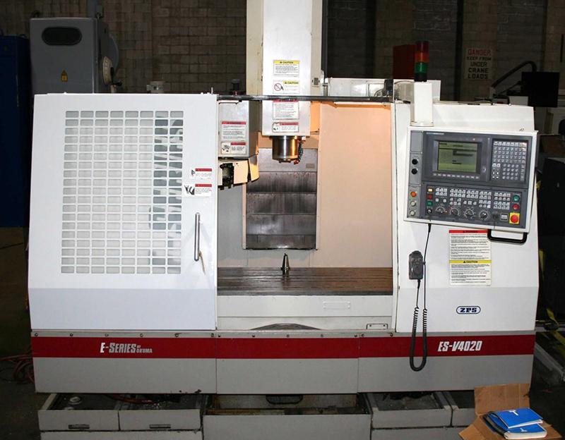 A white CNC vertical machining center with a digital control panel and red accents, positioned in an industrial workspace.