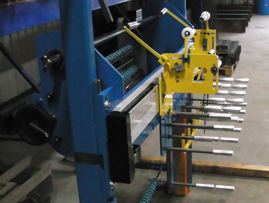 A blue industrial machine with yellow components and a series of horizontal metal rods in a warehouse setting.