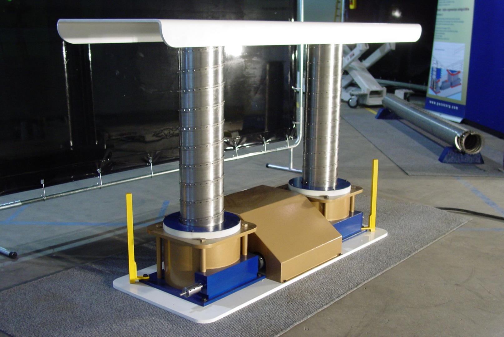 A dual-column industrial lifting mechanism with a white platform, silver textured pillars, and gold-colored base housing.