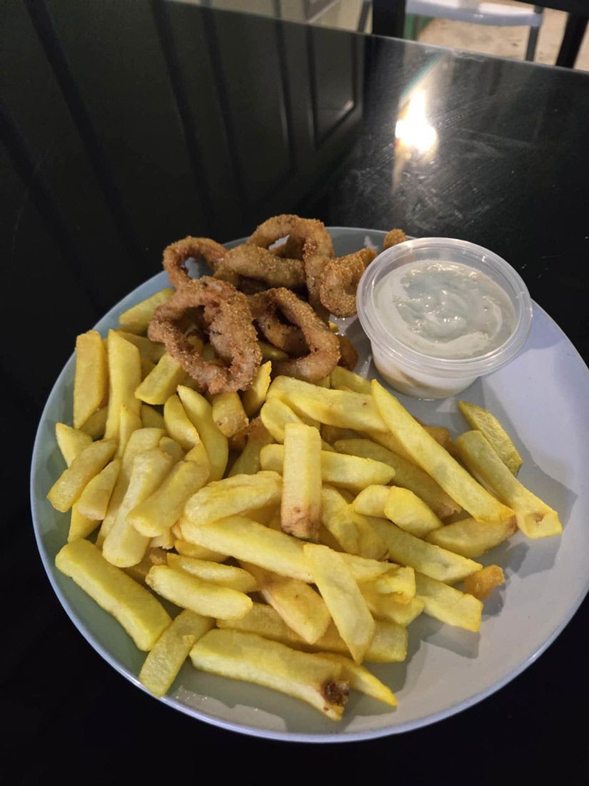 A Plate of French Fries and Fried Calamari on a Table — Deep Sea Delights in Taree, NSW