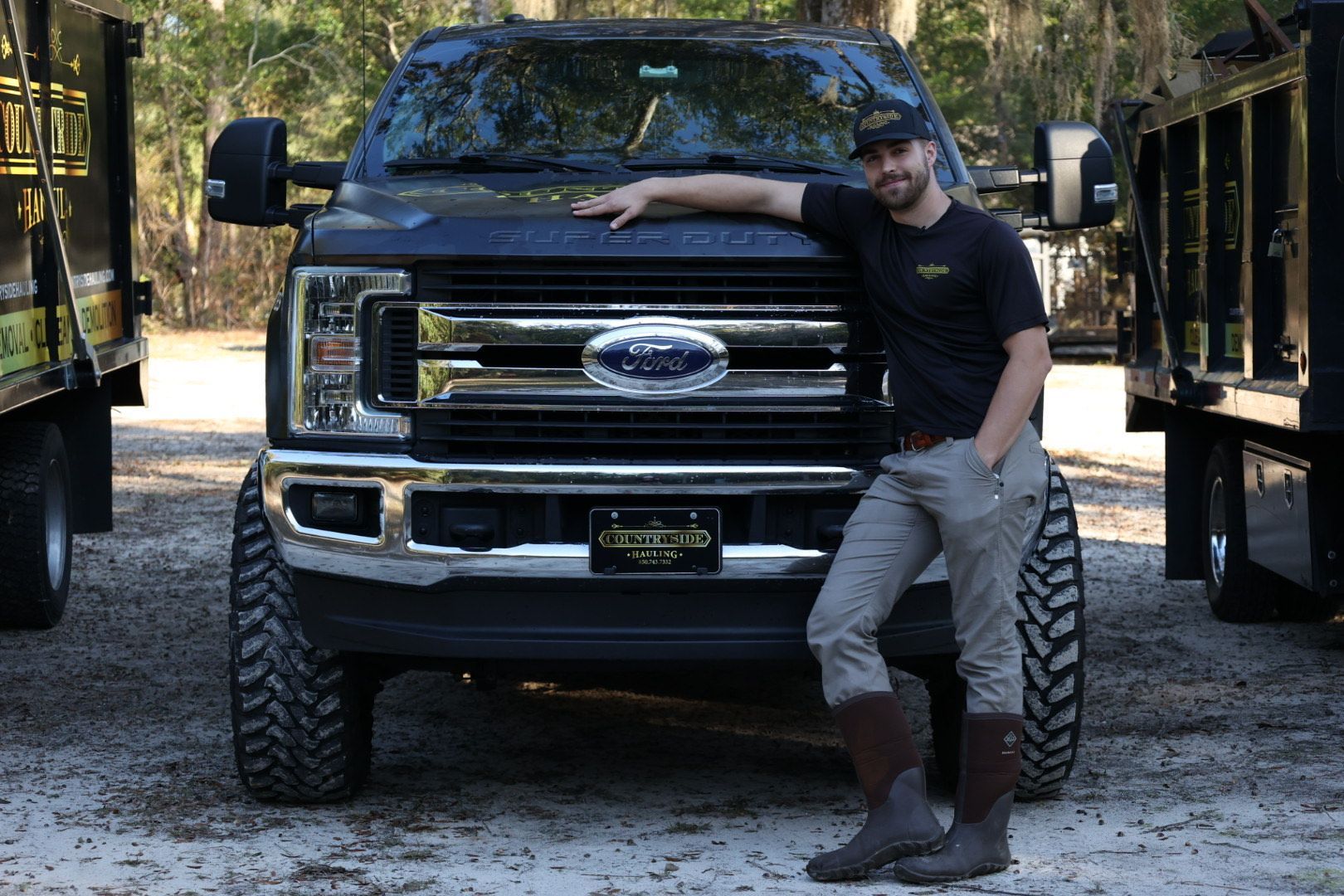 A man is standing in front of a ford truck.
