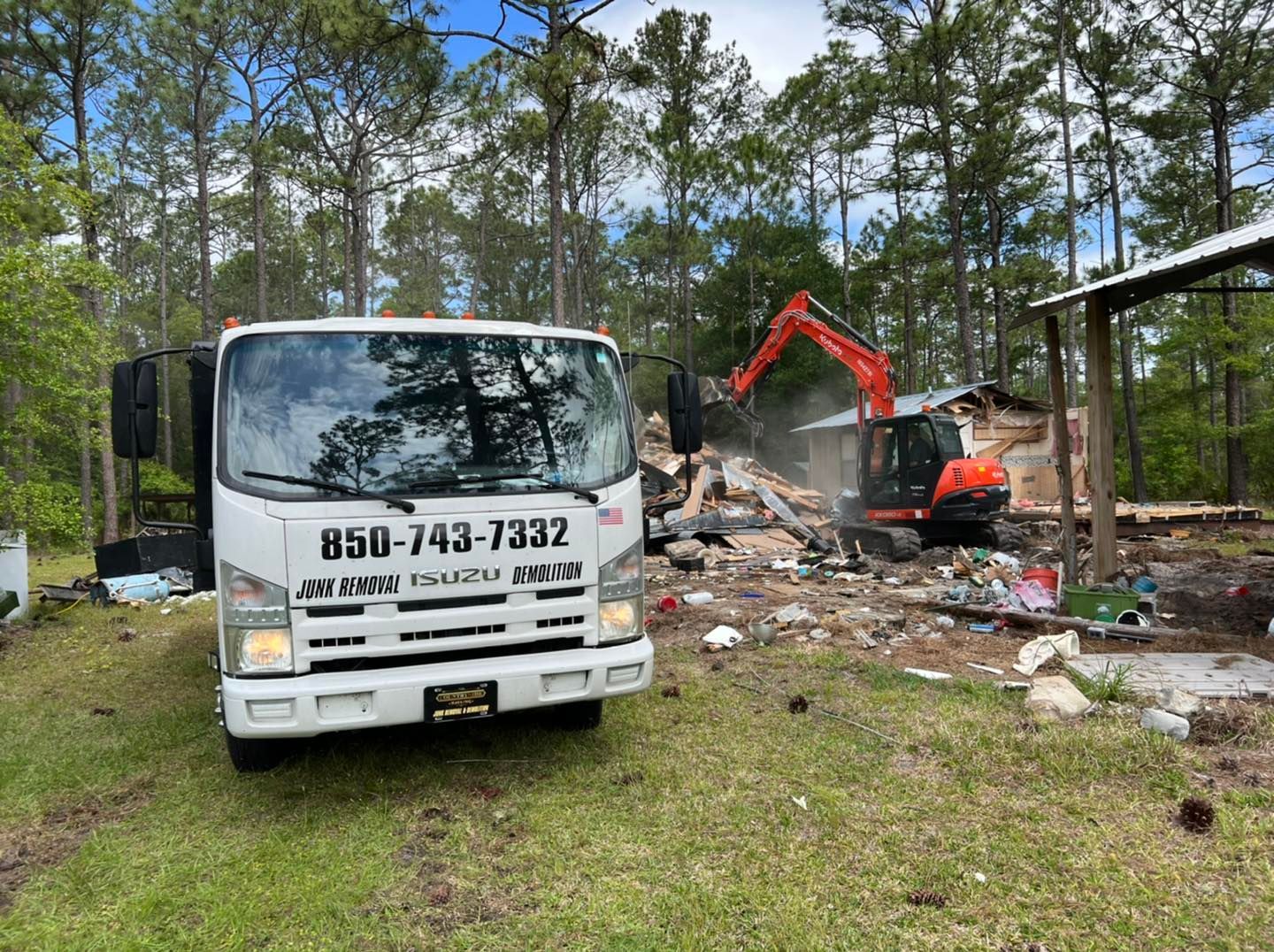 A white truck is parked in front of a house being demolished.