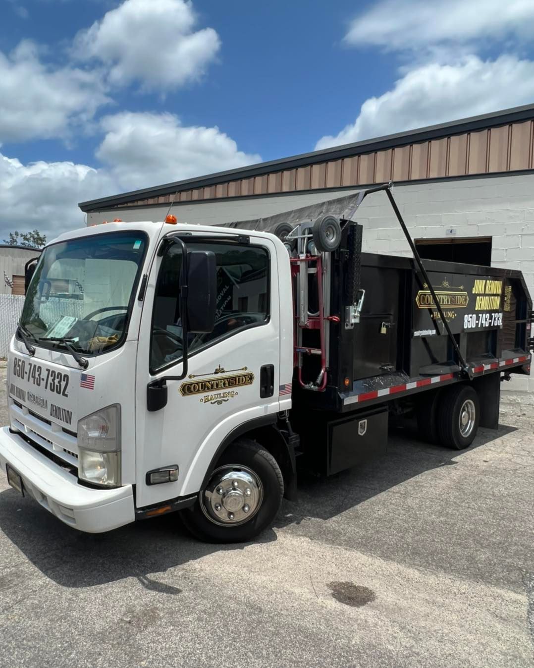 A dump truck is parked in front of a building.