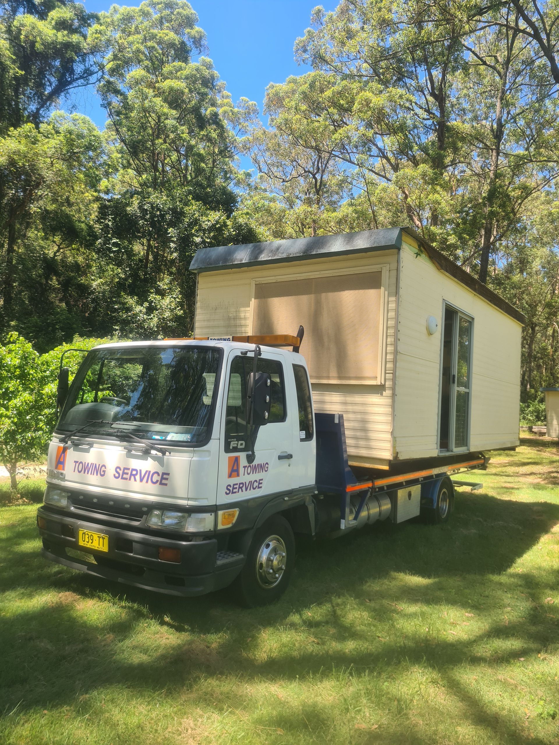 A Truck is Carrying a Small House on the Back of It — A Towing Service In Gloucester, NSW