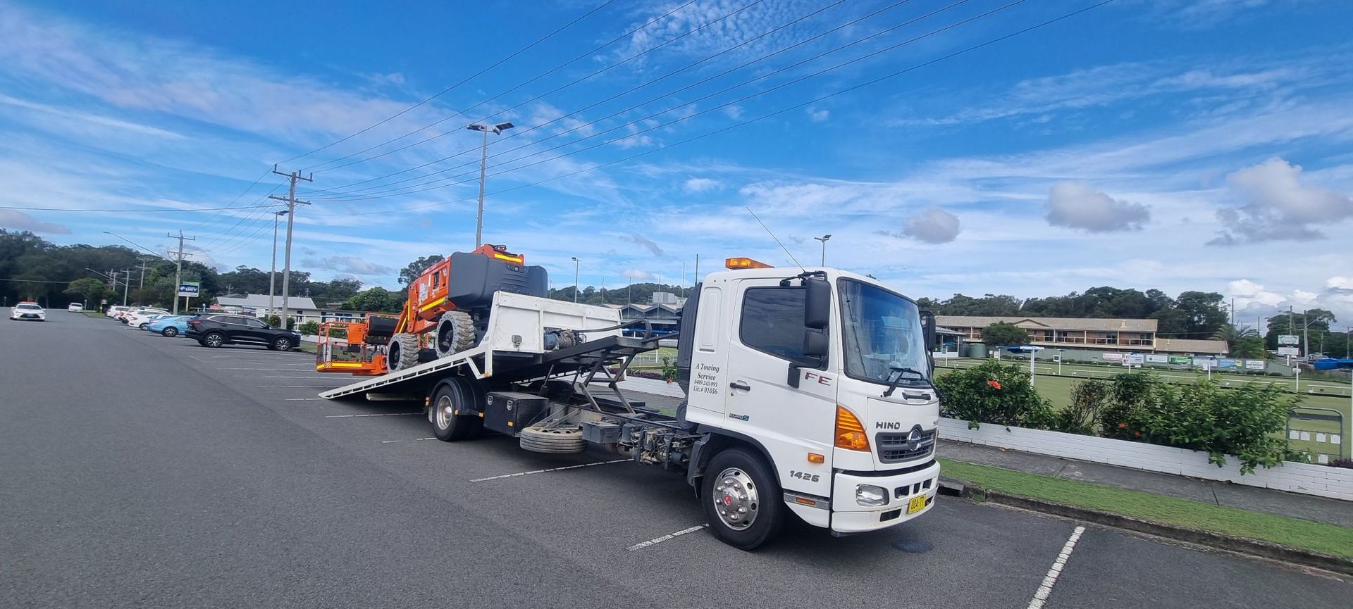 A White Tow Truck is Parked on the Side of the Road — A Towing Service In Forster, NSW