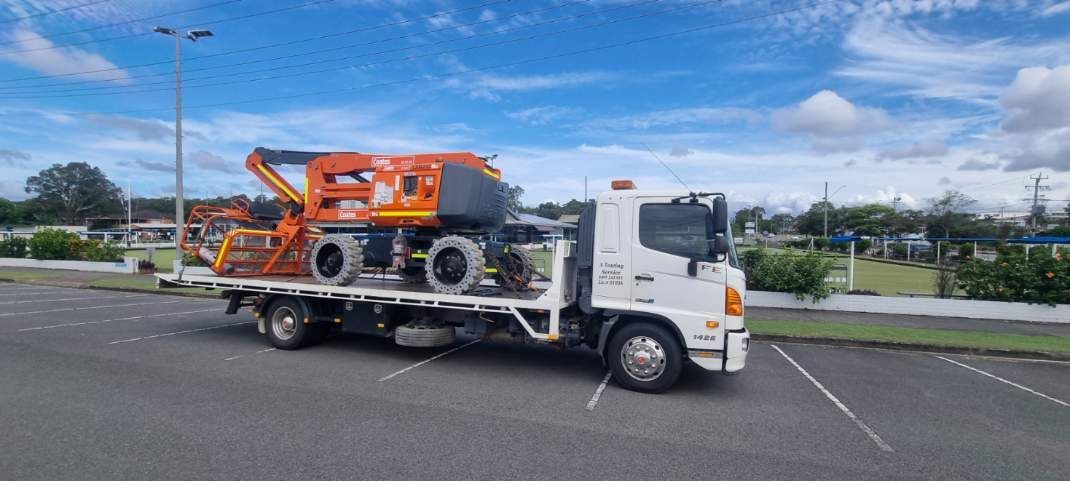 A Tow Truck is Carrying a Crane on the Back of It — A Towing Service In Taree, NSW