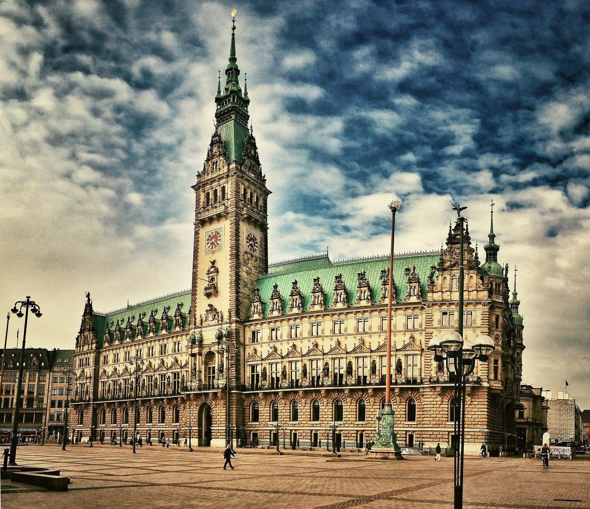 Historisches Hamburger Rathaus im gotischen Stil mit hohem Uhrturm unter bewölktem Himmel 