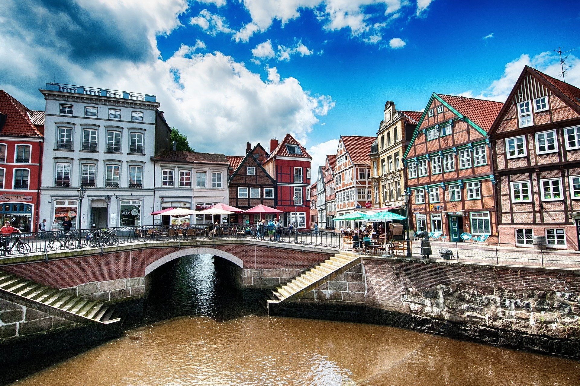 Kanal unter Brücke mit farbenfrohen historischen Gebäuden und blauem Himmel in einer europäischen Stadt