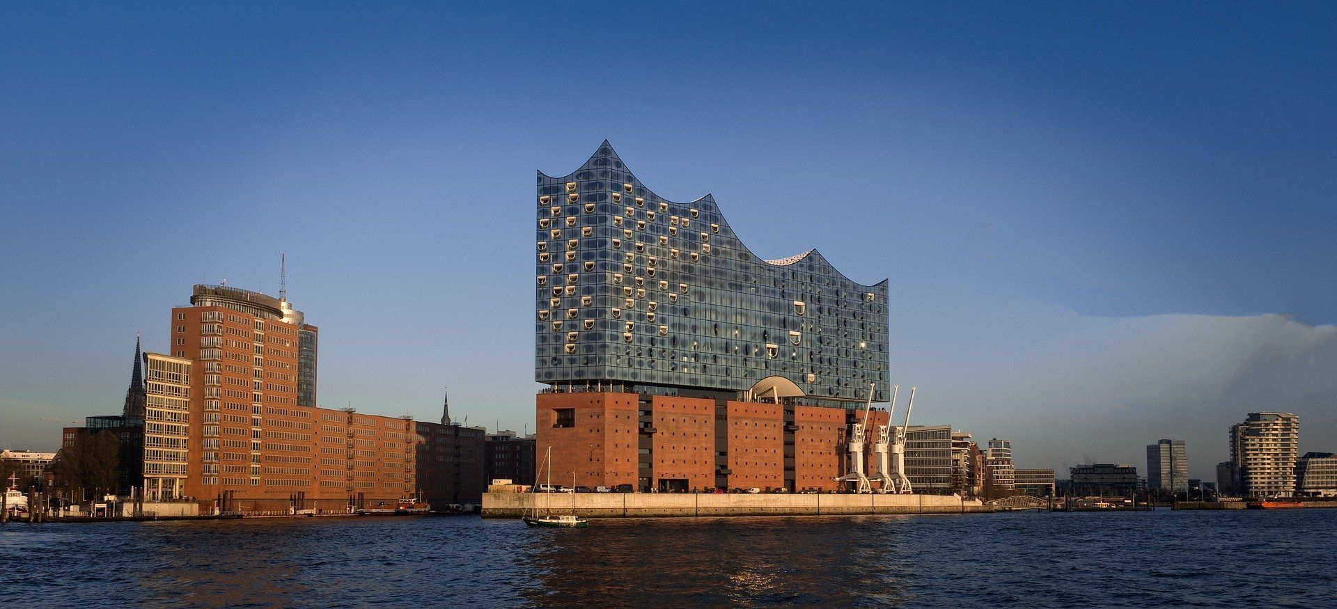 Elbphilharmonie am Wasser  unter klarem blauem Himmel.
