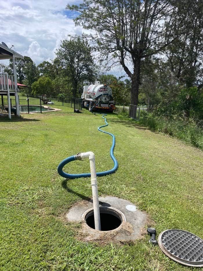 Hose Attached To The Septic Tank With Truck In The Background — Gympie Poo Pumpers in Monkland, QLD