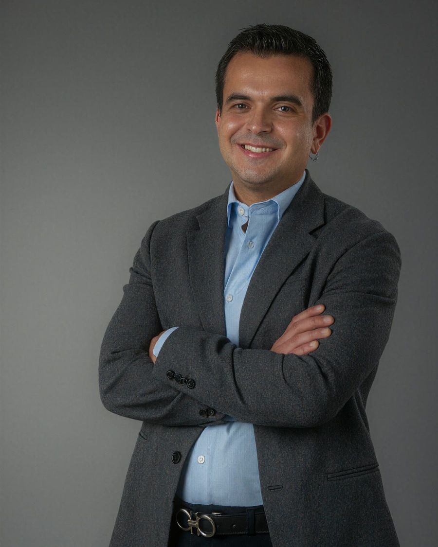 JC in a grey blazer with his arms crossed