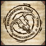 The logo for roadhouse bbq smokehouse is on a wooden barrel.