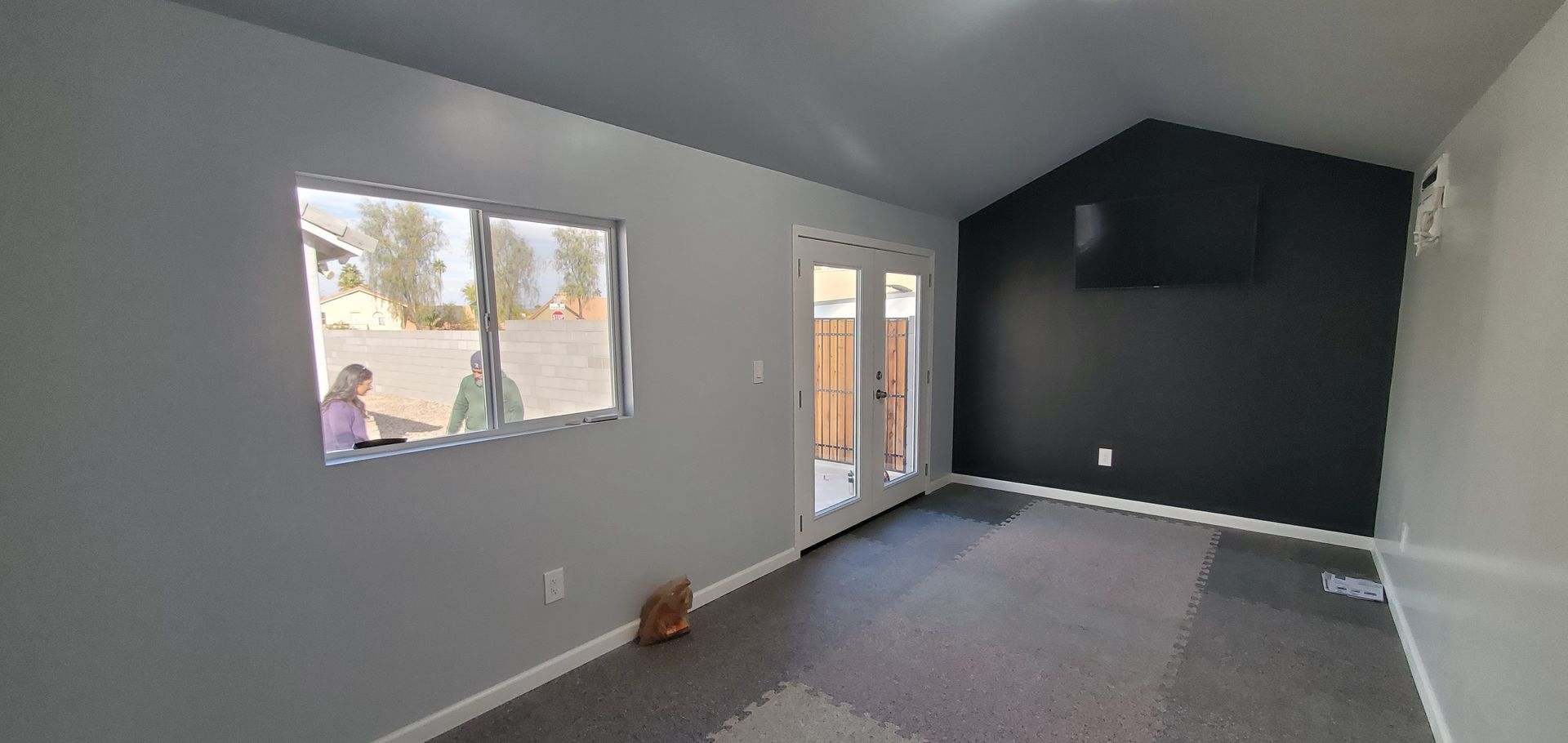 A living room with a vaulted ceiling and sliding glass doors.