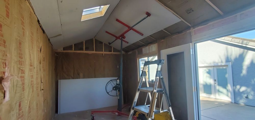 A room with a ladder and a fan in it.