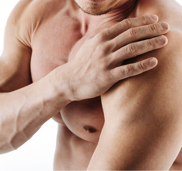 Man holding his shoulder with a pained expression, suggesting shoulder pain or injury