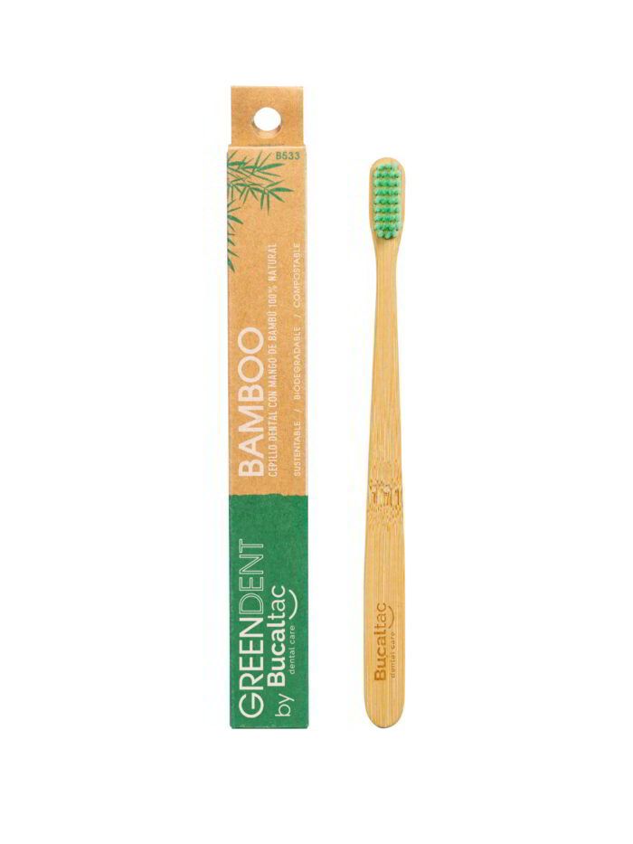Cepillo de dientes de bambú con cerdas verdes junto a su envase de venta al público de color naranja y verde.