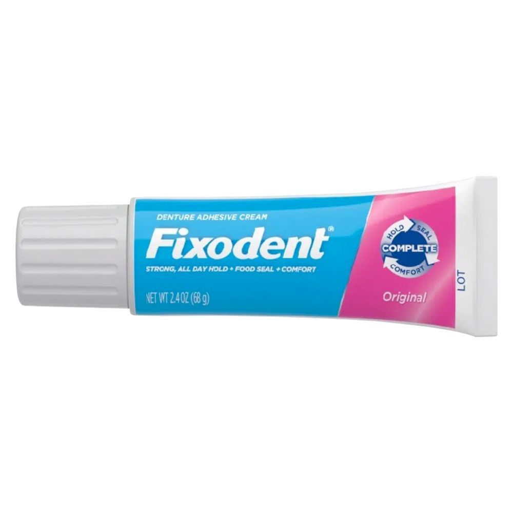 Tubo de crema para prótesis dentales Fixedent, envase azul y rosa sobre fondo blanco.