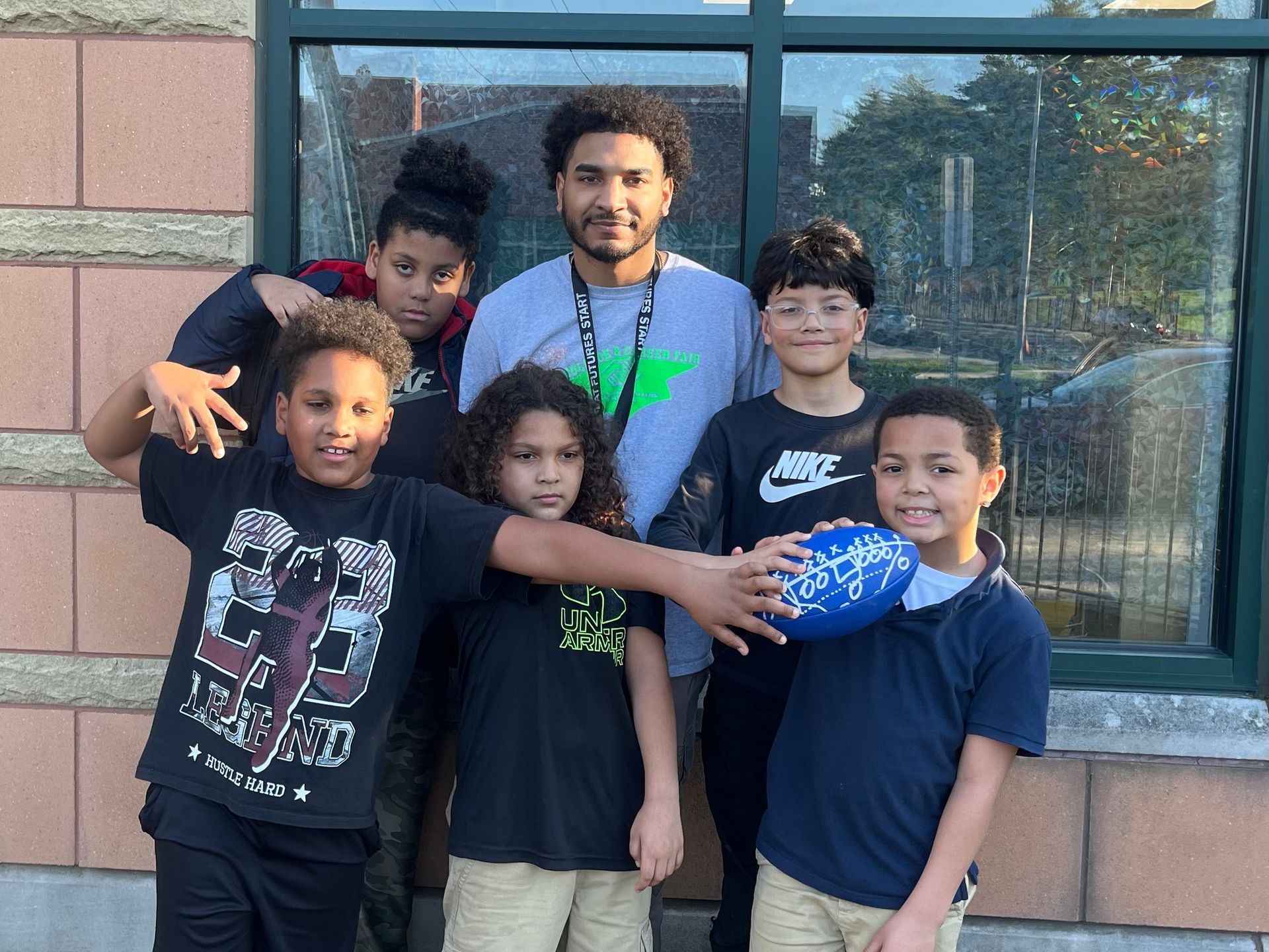 A group of young boys are posing for a picture with the mentor