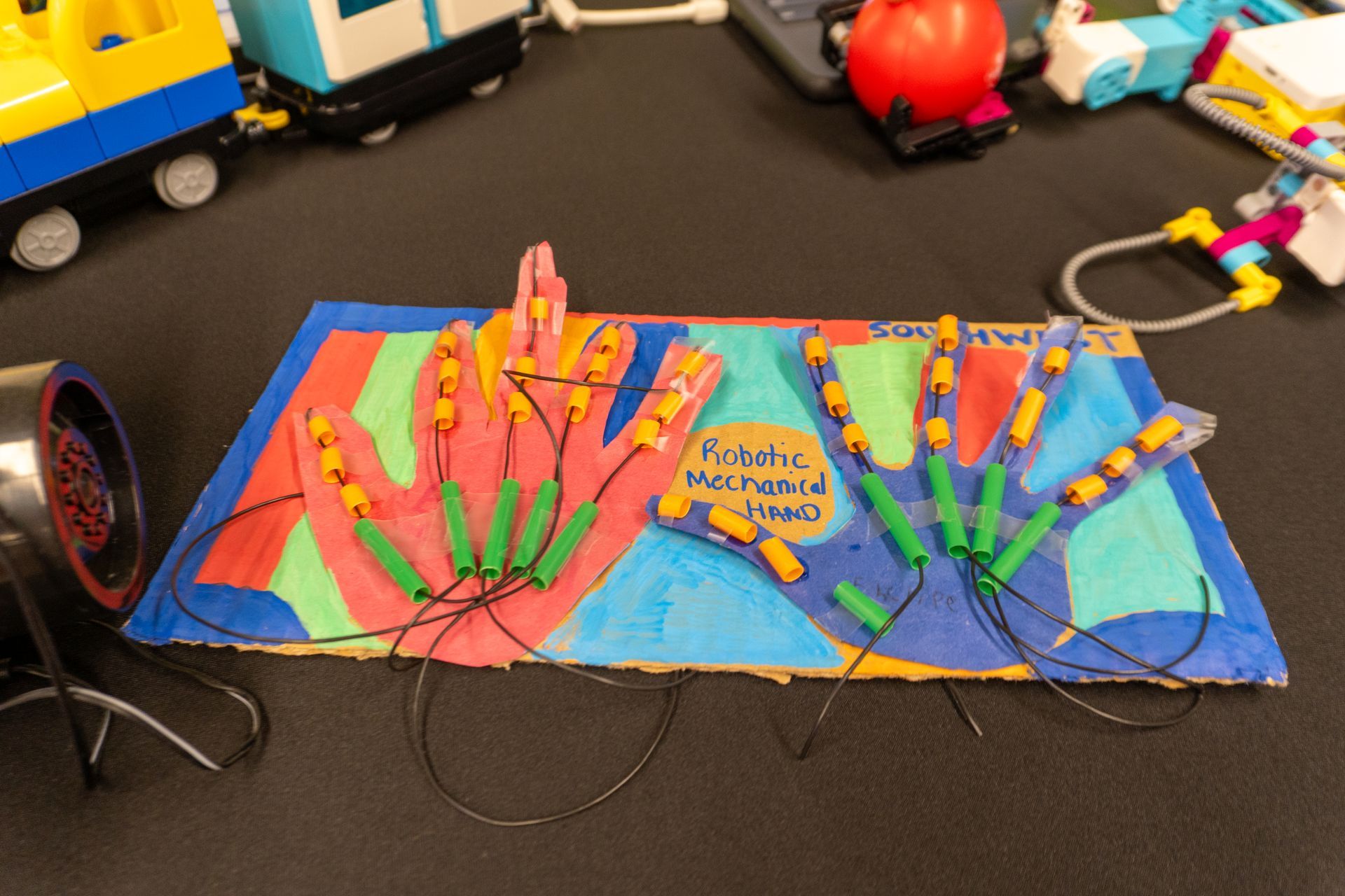 a robotic hand created out of paper, straws and wires 