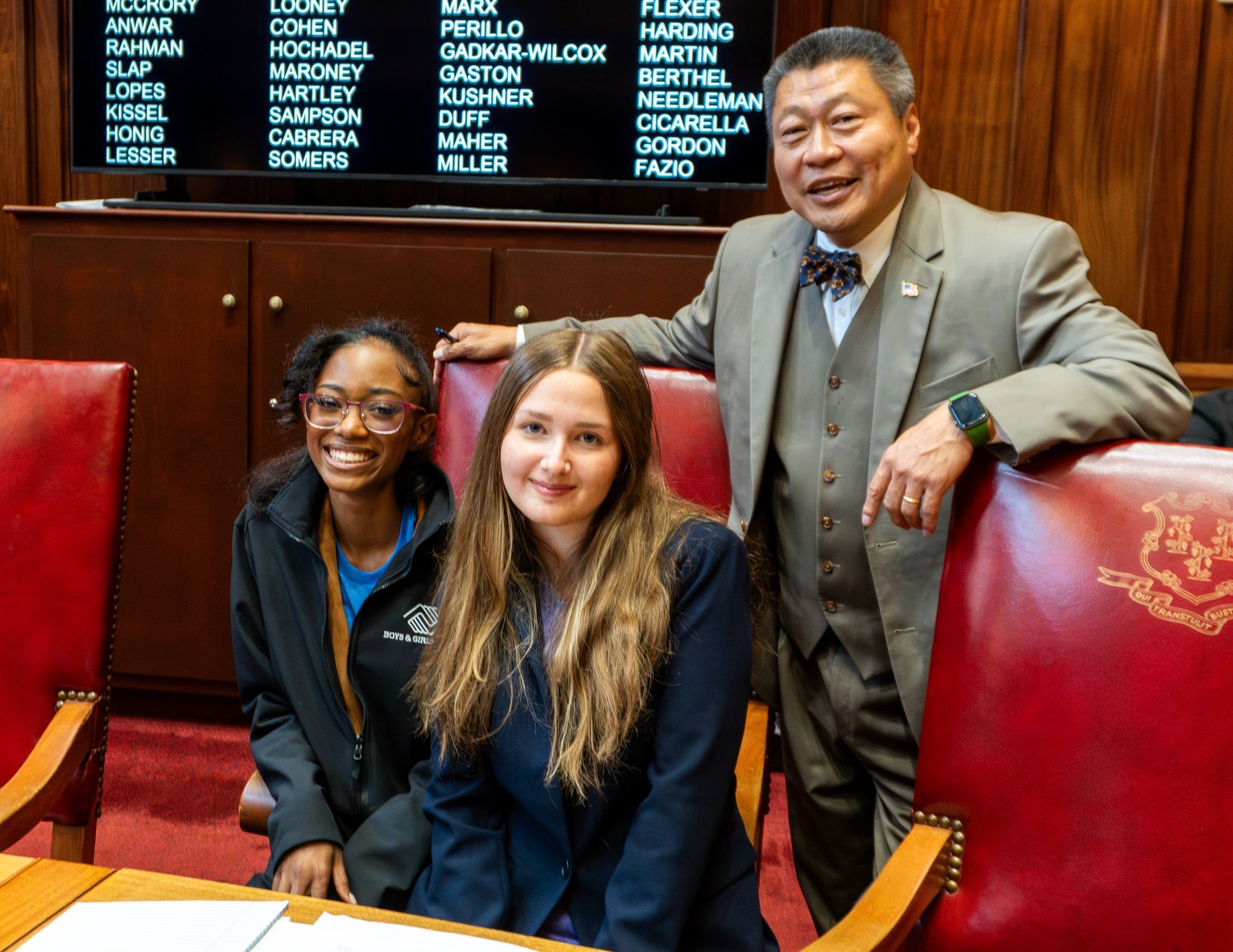A man and two women are posing for a picture in a chamber.