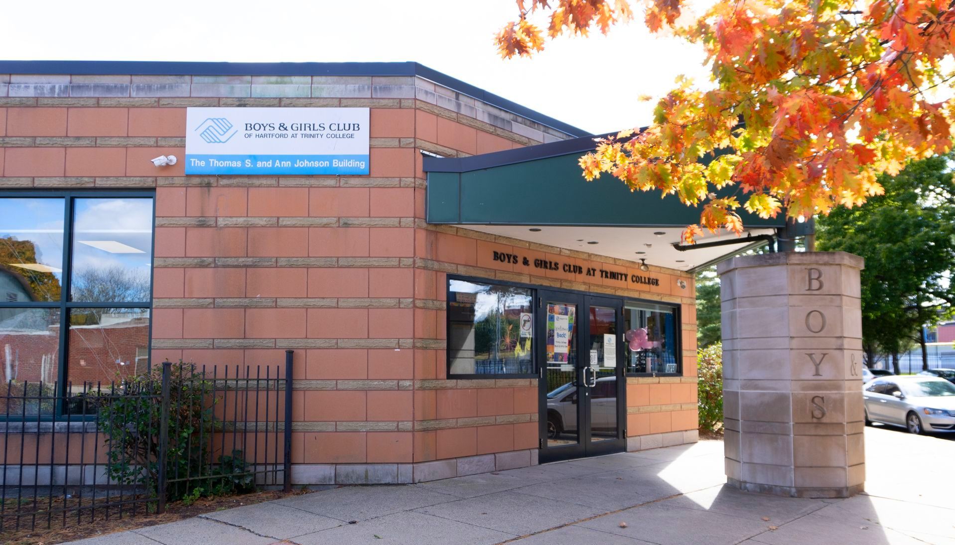 A building with a sign that says boys and girls club at Trinity College on it