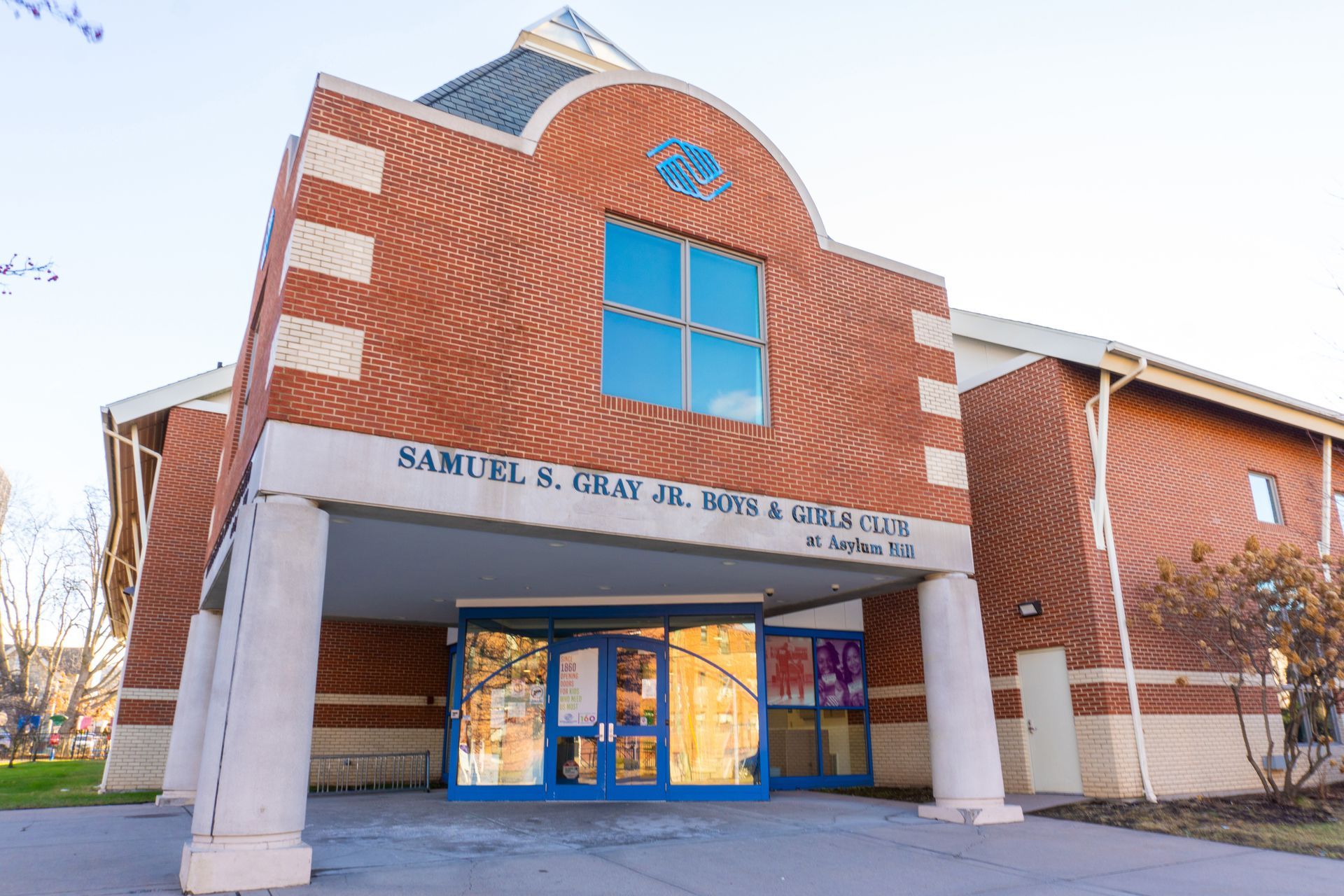 A large brick building with a blue door and a large window