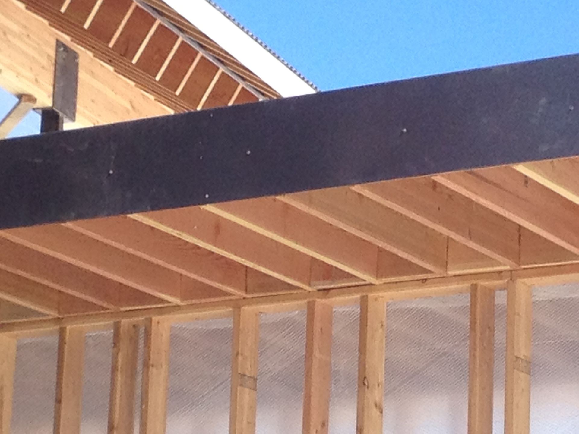 A wooden structure under construction with a blue sky in the background