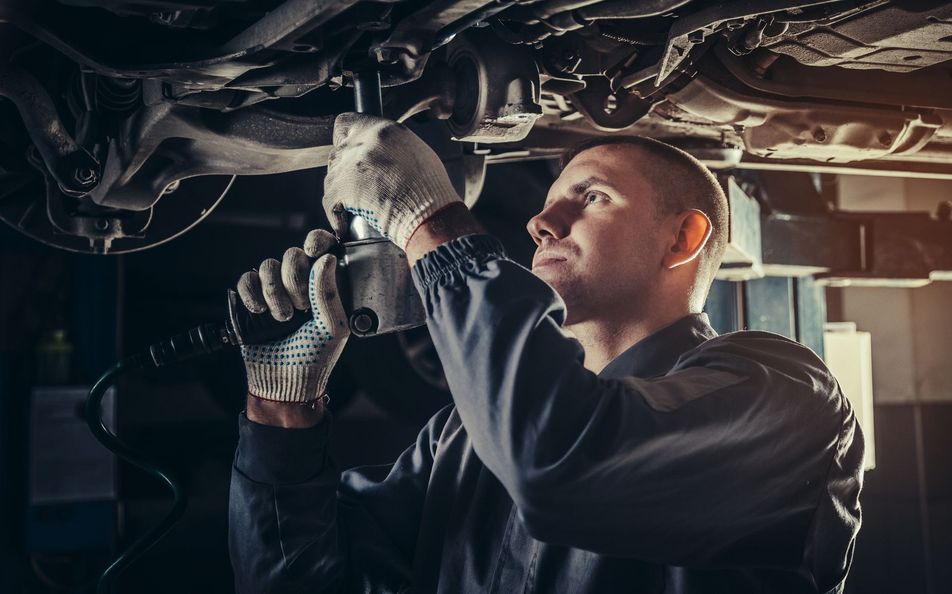 A man is working under a car with a wrench